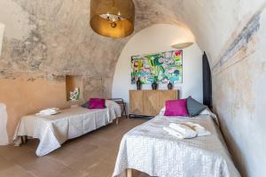a room with two beds and a painting on the wall at Dimora la Pinta ‘700 in Gallipoli +62 photos