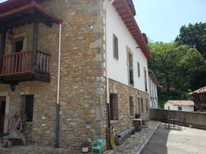 un edificio de piedra con un balcón en un lateral. en el calero, en Oviedo
