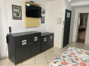 1 dormitorio con 1 cama y TV de pantalla plana en Ipanema Club Hostel, en Río de Janeiro