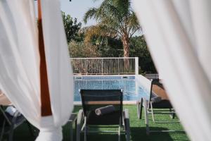 uma vista para uma piscina com 2 cadeiras e uma piscina em VILLA ROMEO 2km FROM IBIZA TOWN AND 1km FROM TALAMANCA BEACH em Santa Eulària des Riu