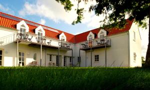 a large white building with a red roof at Aalbæk Badehotel in Ålbæk