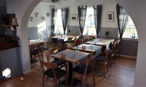 a row of tables and chairs in a restaurant at Aalbæk Badehotel in Ålbæk