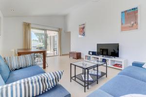 ein Wohnzimmer mit blauen Sofas und einem TV in der Unterkunft Villa Foufou, Cielo de Bonaire in Cielo de Bonaire 