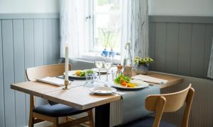 a dining room table with two chairs and two plates of food at Aalbæk Badehotel in Ålbæk