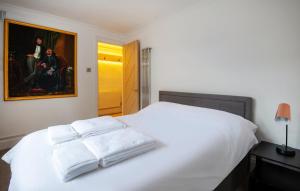 um quarto com uma cama branca com duas toalhas em -NEWLY REFURBISHED- Stylish Apartment 5 minutes from Station w Garden em Brighton & Hove
