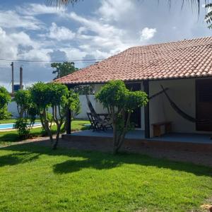 サン・ミゲル・ド・ゴストーゾにあるTropicana Villageの草の中のベンチと木々のある家