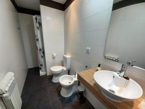 uma casa de banho com um lavatório e um WC em Alojaguay Mariña em Burela de Cabo