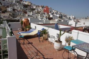 a balcony with chairs and tables and buildings at Riad Tetuanía in Tétouan