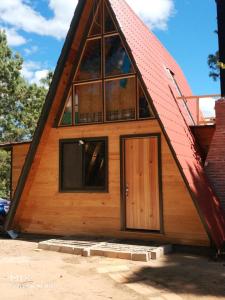 una pequeña casa con techo de gambrel y una puerta en Rancho Samadhi, en El Pacífico