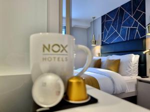a hotel room with a cup and a bed at NOX Edgware Road in London