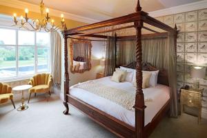 um quarto com uma cama de dossel e um lustre em The Riverside em Salisbury