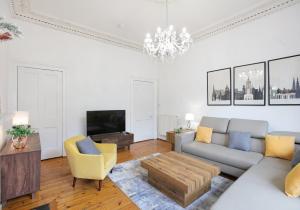 ein Wohnzimmer mit einem Sofa und einem TV in der Unterkunft The Forrest Road Residence in Edinburgh