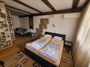 a large bed in a room with a brick wall at Oasis Guest House in Dobrinishte