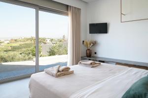 een slaapkamer met een bed en een groot raam bij AGAVE HILL LUXURY HOUSE in Chania +61 foto's