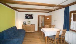 a living room with a table and a blue couch at Ferienwohnung Wruss in Gamlitz