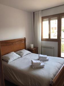 a bedroom with a bed with two towels on it at Casa Buganvilla. Apartamento con jardín, a 100 metros del centro. in Comillas