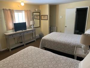 um quarto de hotel com duas camas e uma televisão de ecrã plano em Green Acre Motel em Lake George