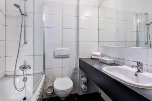 uma casa de banho com um WC, um lavatório e um chuveiro em Best Western Hotel Braunschweig Seminarius em Braunschweig