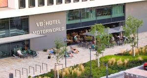an aerial view of a building with people sitting in a courtyard at V8 HOTEL Motorworld Region Stuttgart in Böblingen