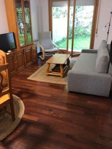 a living room with a couch and a coffee table at Casa Buganvilla. Apartamento con jardín, a 100 metros del centro. in Comillas