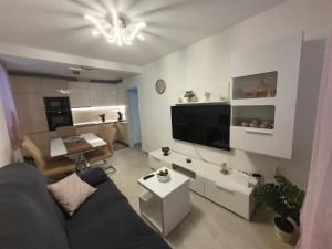 uma sala de estar com um sofá, uma televisão e uma mesa em Apartman Stela em Korčula