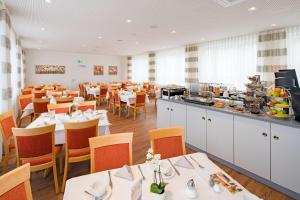 ein Restaurant mit weißen Tischen und Stühlen und einem Buffet in der Unterkunft Best Western Blankenburg Hotel in Coburg