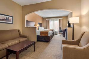 a hotel room with a bed and a couch at Comfort Suites near Route 66 in Springfield