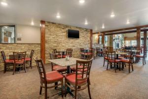 a restaurant with tables and chairs and a brick wall at Comfort Suites near Route 66 in Springfield