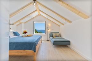 ein Schlafzimmer mit einem Bett und einer Couch und einem Fenster in der Unterkunft Seaside Cottage Maslina in Gdinj