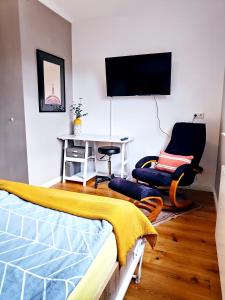 a bedroom with a bed and a desk and a tv at Mini-Apartment ruhig und verkehrsgünstig in Berlin in Berlin