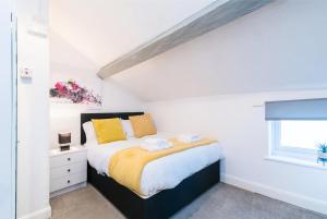 een slaapkamer met een bed met gele kussens en een raam bij DD Apartment 8 - Free Parking - Fast Wifi in Castle Donington