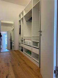 um quarto com prateleiras brancas e piso de madeira em Loft in bester Lage em Landau in der Pfalz