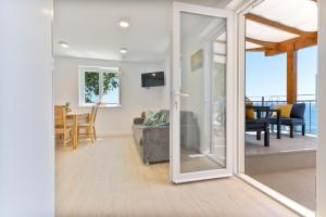 ein Wohnzimmer mit einer Glasschiebetür in der Unterkunft Seaside Cottage Maslina in Gdinj