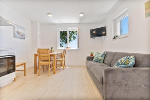 ein Wohnzimmer mit Sofa und Tisch in der Unterkunft Seaside Cottage Maslina in Gdinj