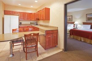 a kitchen with a room with a bed and a table at Holiday Inn Express Hotel & Suites Barstow, an IHG Hotel in Barstow