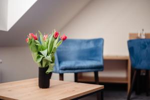 a vase of red tulips sitting on a table at Landhotel Freitag in Sankt Paul im Lavanttal