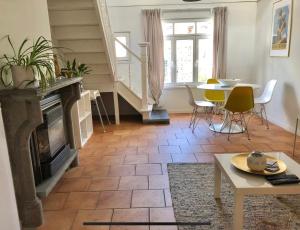 sala de estar con chimenea y mesa en t Hoeveke en Ostende