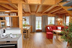 a living room with a red couch and a table at Landhaus Anja in Freudenstadt