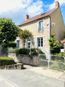 a house with a fence in front of it at Les 3 Gamins in Boussac