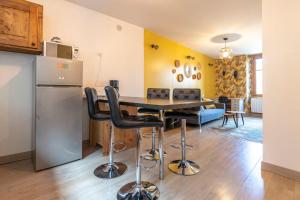 a kitchen and dining room with a table and a refrigerator at Reflet des Alpes Furnished flat in Annecy
