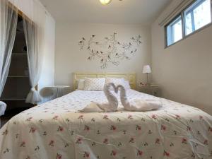Dos toallas de cisne en una cama en un dormitorio en Vilajubi II, en Sotillo de la Adrada