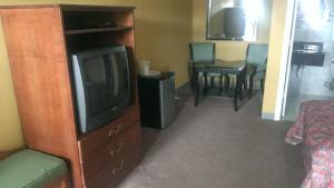 a living room with a television and a dining room at Naugatuck Motor Lodge in Naugatuck