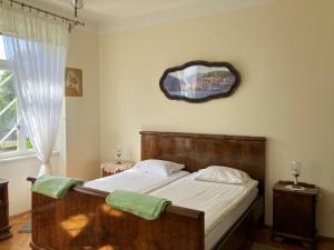 a bedroom with a wooden bed with a mirror on the wall at Apartman Villa Amelia in Mošćenička Draga
