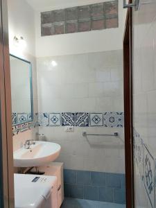 uma casa de banho com um lavatório e uma banheira em Luna blu em Erchie