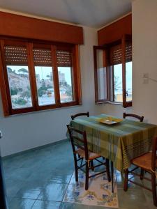 a dining room with a table and chairs and windows at Luna Blu in Erchie +4 photos