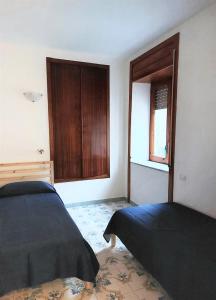 um quarto com 2 camas e um armário de madeira em Luna blu em Erchie