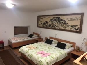 a bedroom with two beds and a painting on the wall at Prenoćište Gany in Jajce