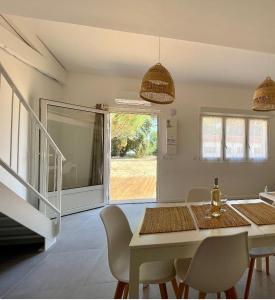 a white dining room with a table and chairs at Les Salines Oléron in Saint-Pierre-dʼOléron