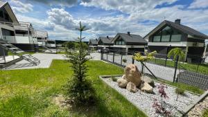 a garden with a small tree and some houses at Domy na Roztoczu Aleja Lipowa - dom H in Zwierzyniec