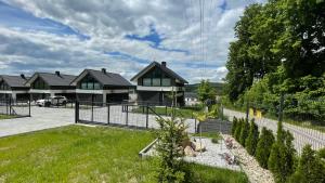 a house with a fence in front of a yard at Domy na Roztoczu Aleja Lipowa - dom H in Zwierzyniec